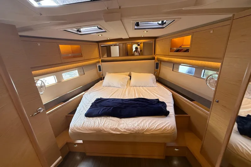 Tupelo Honey Yacht Photos Pics Luxurious cabin interior of 2022 Dufour 530 yacht with cozy bedding and modern design.