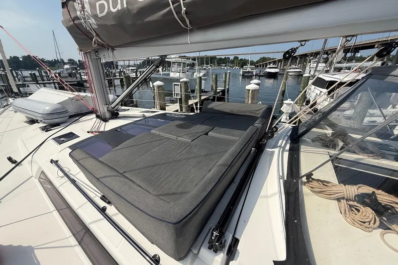 Tupelo Honey Yacht Photos Pics 2022 Dufour 530 yacht with cushioned deck, docked at marina with boats and bridge.