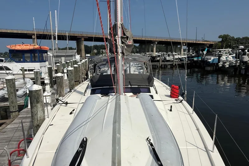Tupelo Honey Yacht Photos Pics 2022 Dufour 530 sailboat docked at a marina, with clear skies and calm waters.