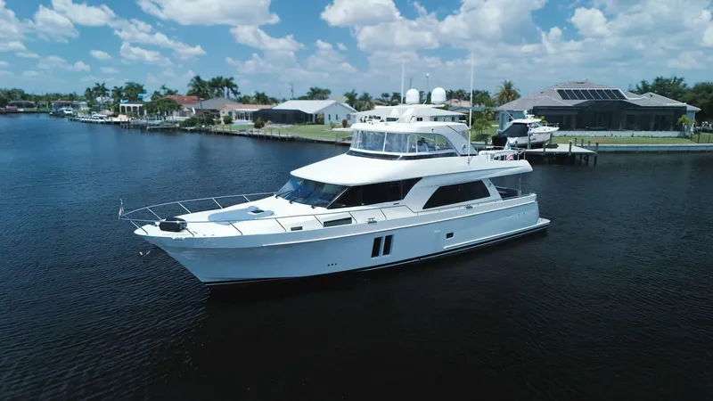 Psyche Yacht Photos Pics Luxury 2015 Ocean Alexander 72 yacht cruising on a serene waterway under a clear blue sky.