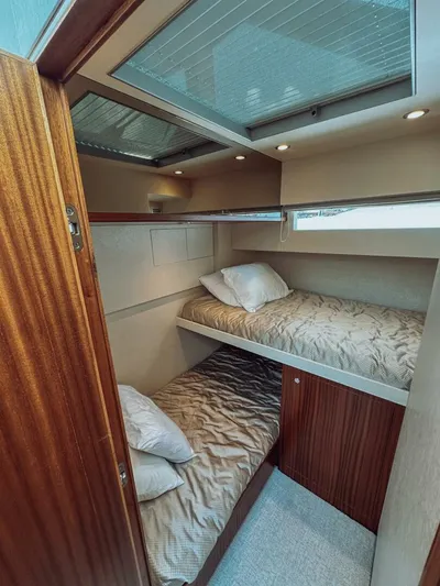 Psyche Yacht Photos Pics Bunk beds in 2015 Ocean Alexander 72 yacht cabin, featuring wood paneling and cozy bedding.