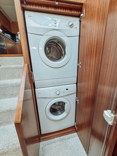 Psyche Yacht Photos Pics Stacked washer and dryer in 2015 Ocean Alexander 72 yacht's wooden cabinet.