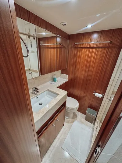 Psyche Yacht Photos Pics Luxurious bathroom in 2015 Ocean Alexander 72 yacht with wood paneling and modern fixtures.
