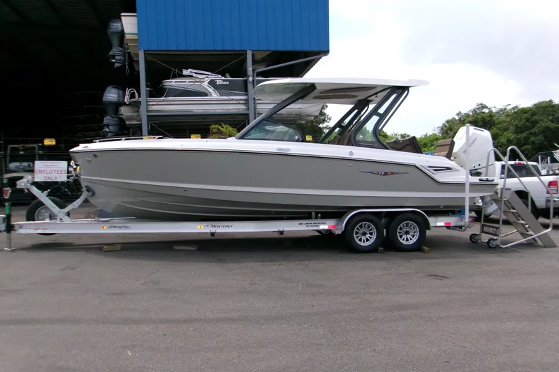  Yacht Photos Pics 2026 Monterey Elite 27 OB boat on trailer, parked outdoors.