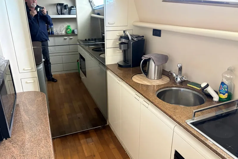 Rabbit Yacht Photos Pics Galley kitchen in 1999 Ferretti Yachts 80 RPH with modern appliances and wood flooring.