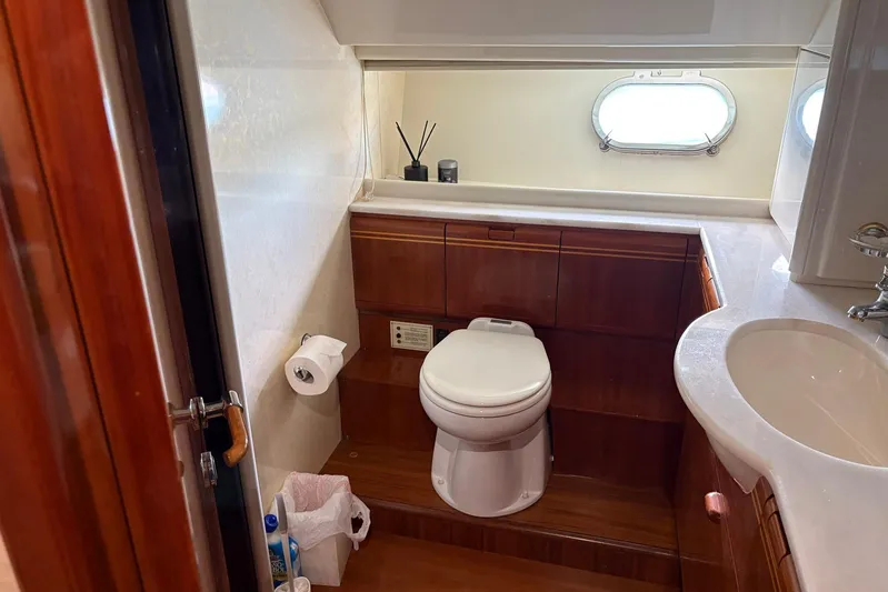 Rabbit Yacht Photos Pics Luxurious bathroom in 1999 Ferretti Yachts 80 RPH with wooden cabinetry and porthole window.