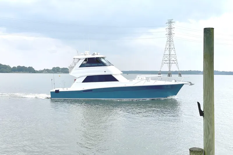  Yacht Photos Pics 1999 Riviera Convertible SF yacht cruising on calm waters under a cloudy sky.