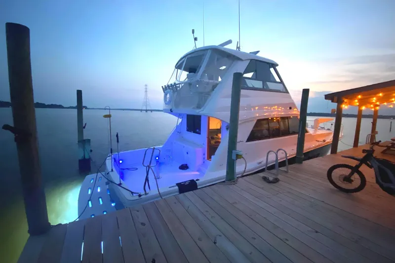  Yacht Photos Pics 1999 Riviera Convertible SF yacht docked at sunset with glowing blue lights.