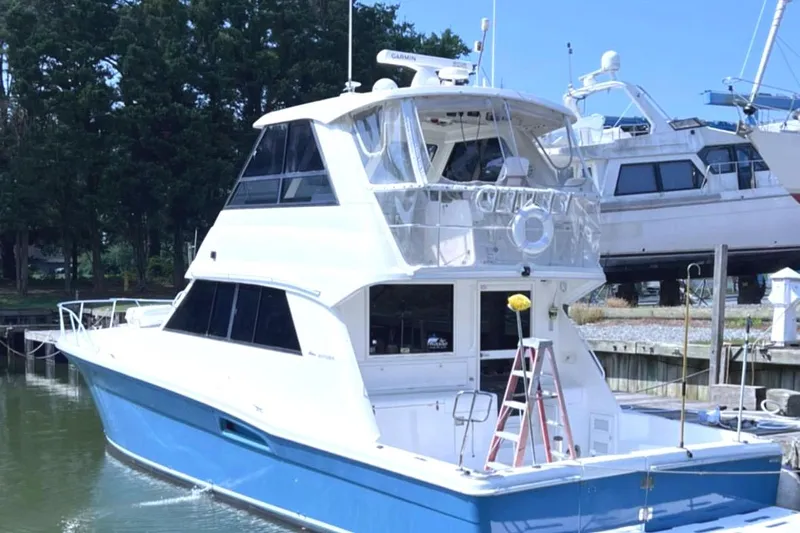  Yacht Photos Pics 1999 Riviera Convertible SF boat docked, featuring a sleek blue and white design.