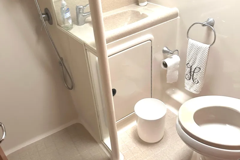  Yacht Photos Pics Compact bathroom in 1999 Riviera Convertible SF, featuring shower, sink, and toilet.