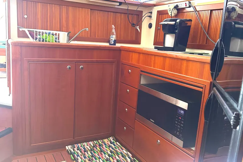  Yacht Photos Pics 1999 Riviera Convertible SF yacht kitchen with wooden cabinets, microwave, and coffee maker.
