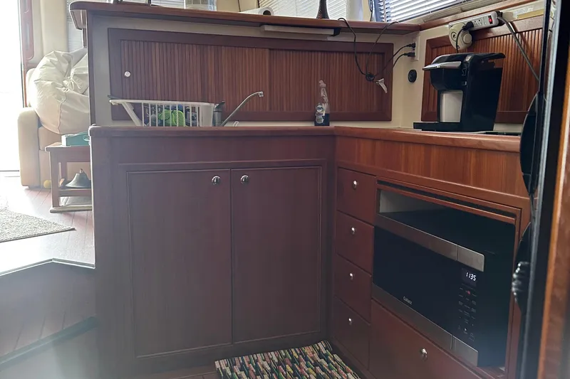  Yacht Photos Pics 1999 Riviera Convertible SF yacht kitchen with wooden cabinets, microwave, and coffee maker.