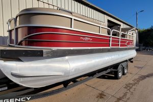 2019 Sun Tracker Party Barge 24 DLX pontoon boat on trailer, parked outside a building.