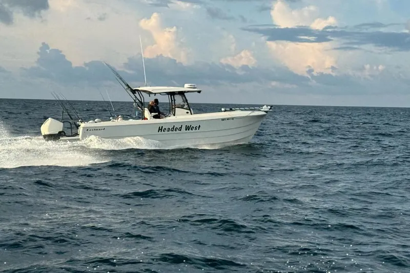  Yacht Photos Pics Eastward 30 boat cruising on the ocean, 2022 model, with fishing rods and cloudy sky.