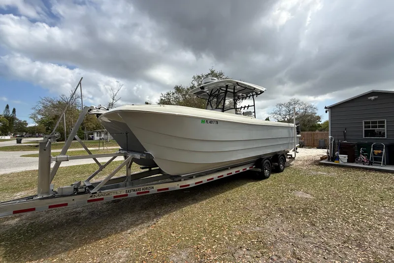  Yacht Photos Pics 2022 Eastward 30 boat on trailer, parked outdoors under cloudy sky.