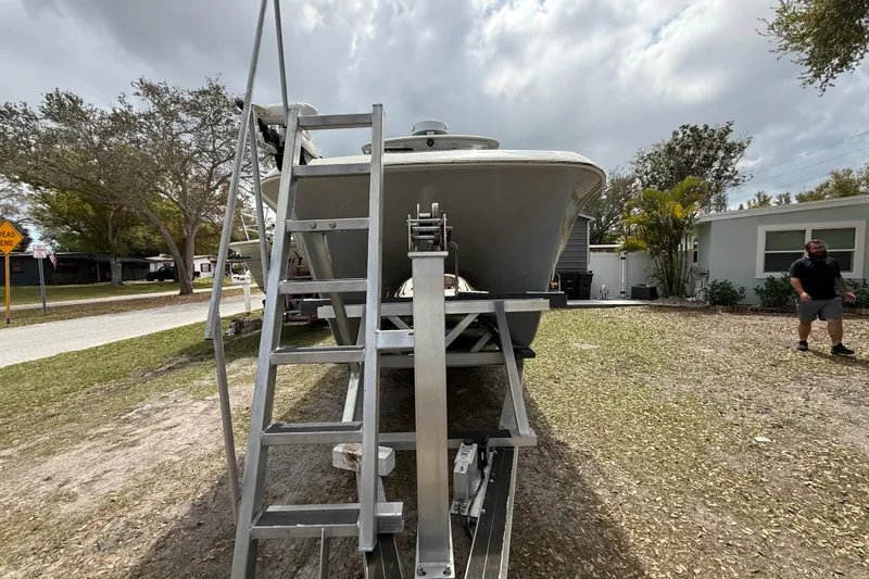  Yacht Photos Pics 2022 Eastward 30 boat on trailer with ladder, parked in residential area.