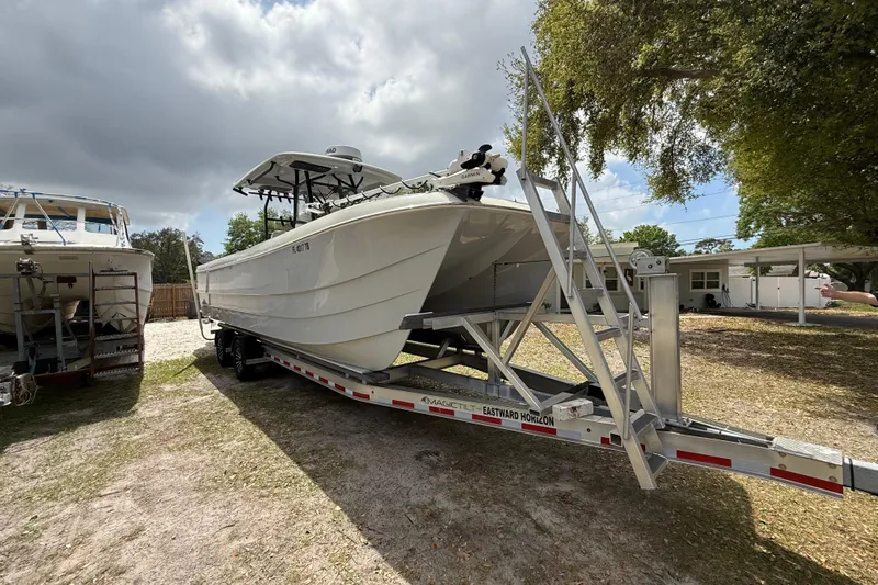  Yacht Photos Pics 2022 Eastward 30 boat on trailer under cloudy sky, parked outdoors.