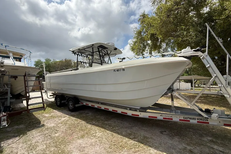  Yacht Photos Pics 2022 Eastward 30 boat on trailer under cloudy sky, parked outdoors.