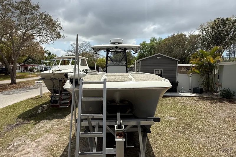  Yacht Photos Pics 2022 Eastward 30 boat on trailer, parked outdoors under cloudy sky.