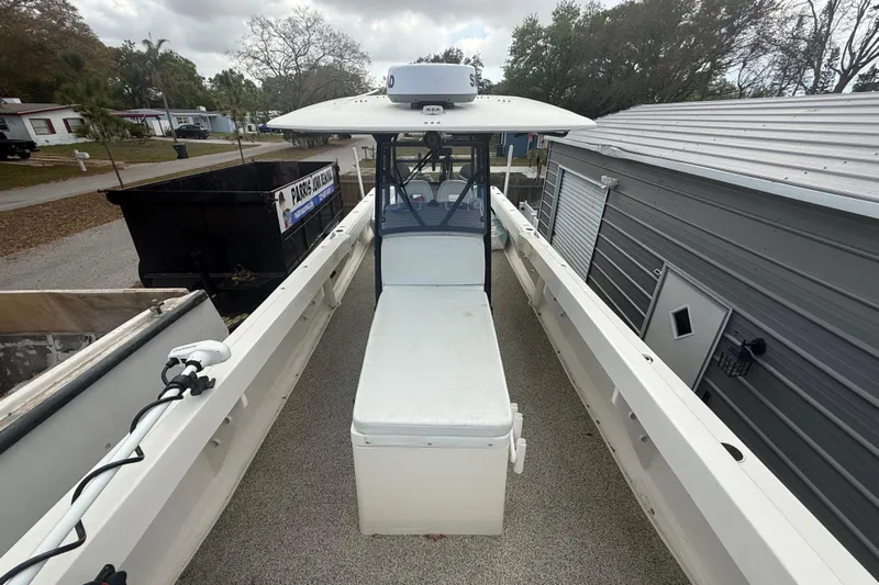  Yacht Photos Pics 2022 Eastward 30 boat docked beside a metal building, showcasing spacious deck layout.