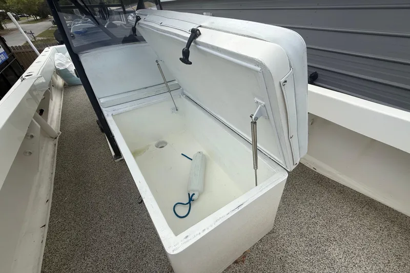  Yacht Photos Pics Open storage compartment on a 2022 Eastward 30 boat, featuring a white interior and hydraulic supports.