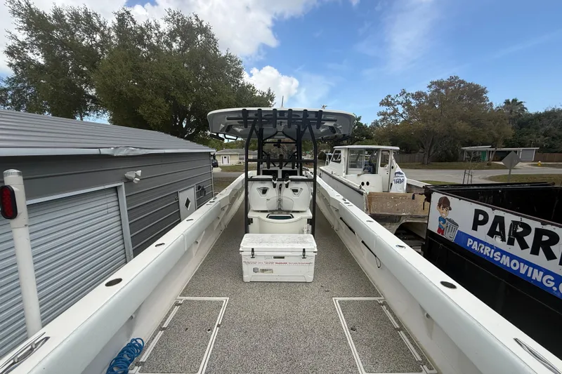  Yacht Photos Pics 2022 Eastward 30 boat with center console and storage, docked near trees and buildings.