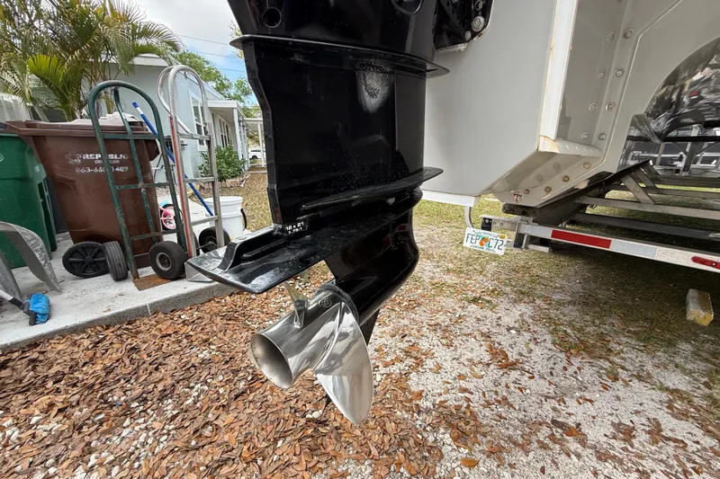  Yacht Photos Pics Close-up of a 2022 Eastward 30 boat propeller and outboard motor in a yard setting.