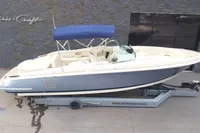 2024 Chris-Craft Launch 28 GT boat with blue canopy on trailer.