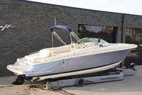 2024 Chris-Craft Launch 28 GT boat on trailer, sleek design, blue and white exterior.