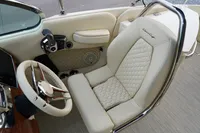 2024 Chris-Craft Launch 28 GT cockpit with luxurious cream leather seating and elegant steering wheel.