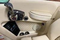 2024 Chris-Craft Launch 28 GT interior, featuring control panel and luxurious beige upholstery.