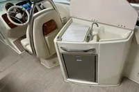 2024 Chris-Craft Launch 28 GT interior with steering wheel and compact kitchenette.