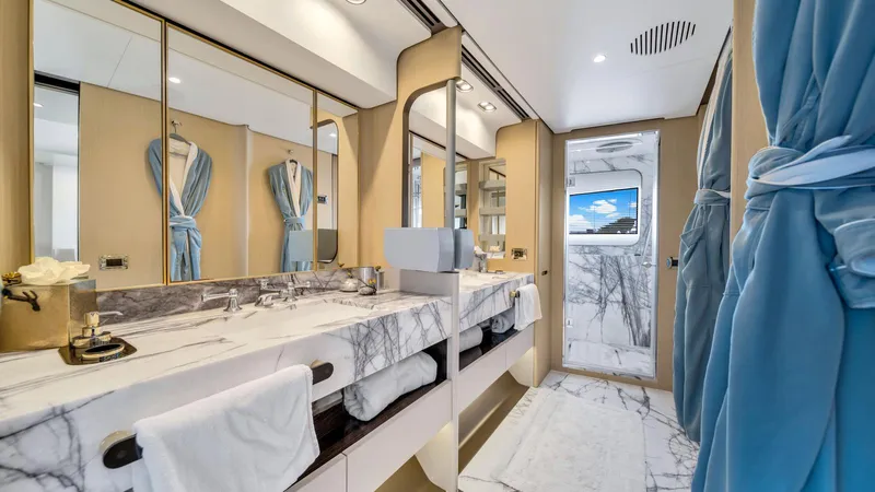 One & Only Yacht Photos Pics Luxurious bathroom on 2020 Azimut Grande 32 Metri yacht with marble countertops and blue robes.
