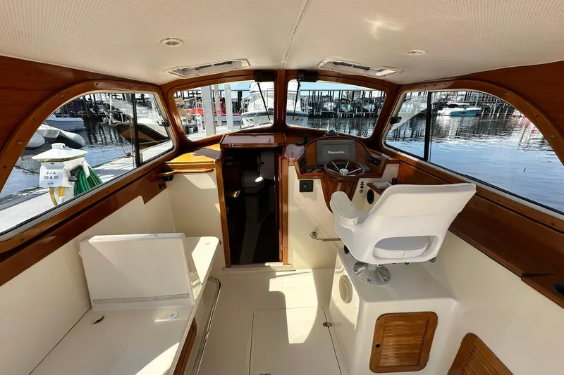 Lida Yacht Photos Pics Interior of 2000 Hinckley Picnic Boat 36 with helm and seating, docked at marina.