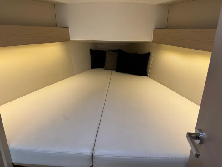 Stinger Yacht Photos Pics Cozy cabin interior of 2022 Beneteau Oceanis 30.1 sailboat with soft lighting and cushions.