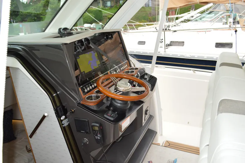 Encore Yacht Photos Pics 2023 Tiara Yachts 34 LS helm with modern navigation equipment and wooden steering wheel.