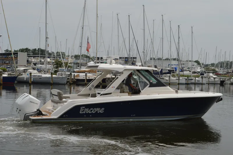 Encore Yacht Photos Pics 2023 Tiara Yachts 34 LS boat docked in a marina with sailboats.