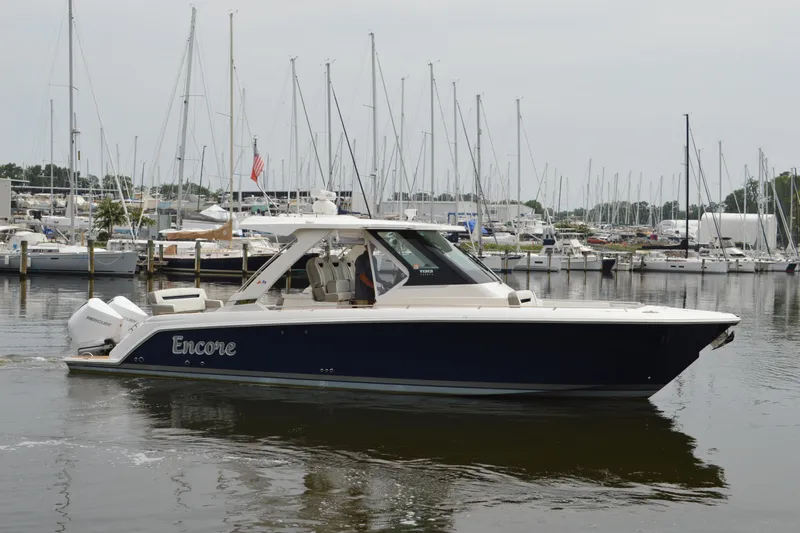 Encore Yacht Photos Pics 2023 Tiara Yachts 34 LS boat docked in marina, surrounded by sailboats.