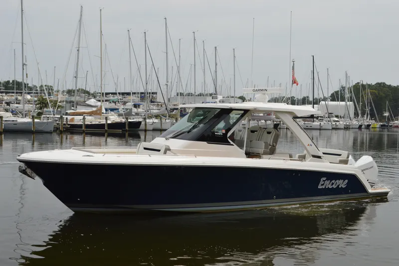 Encore Yacht Photos Pics 2023 Tiara Yachts 34 LS boat docked in marina, surrounded by sailboats.