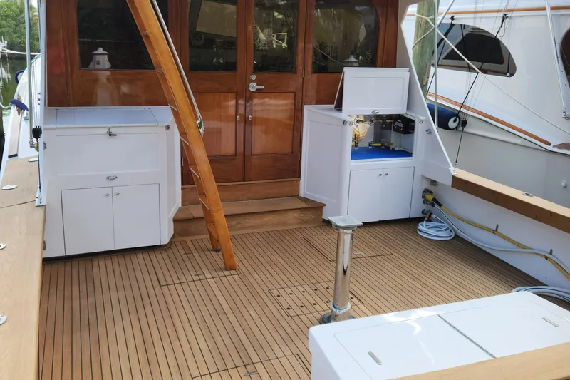 Miss Phebe II Yacht Photos Pics 1971 Whiticar Sportfish boat deck with wooden flooring and white storage units.