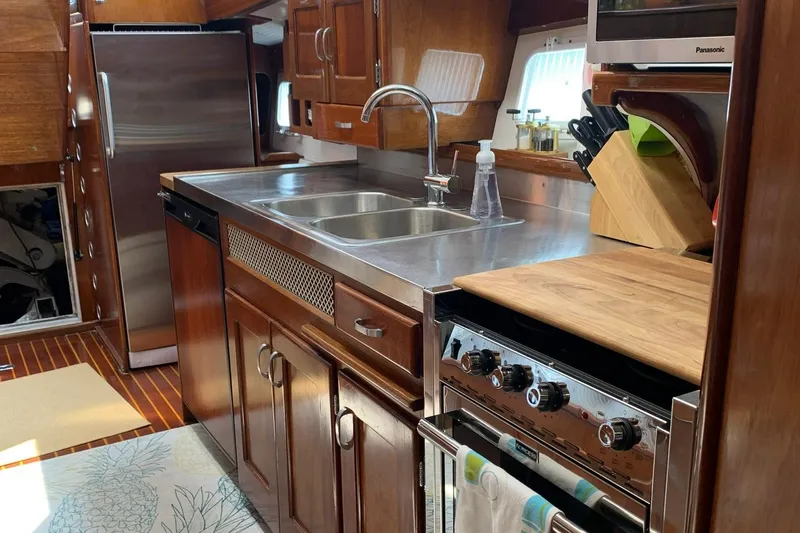Miss Phebe II Yacht Photos Pics 1971 Whiticar Sportfish kitchen with stainless steel sink, wooden cabinets, and modern appliances.