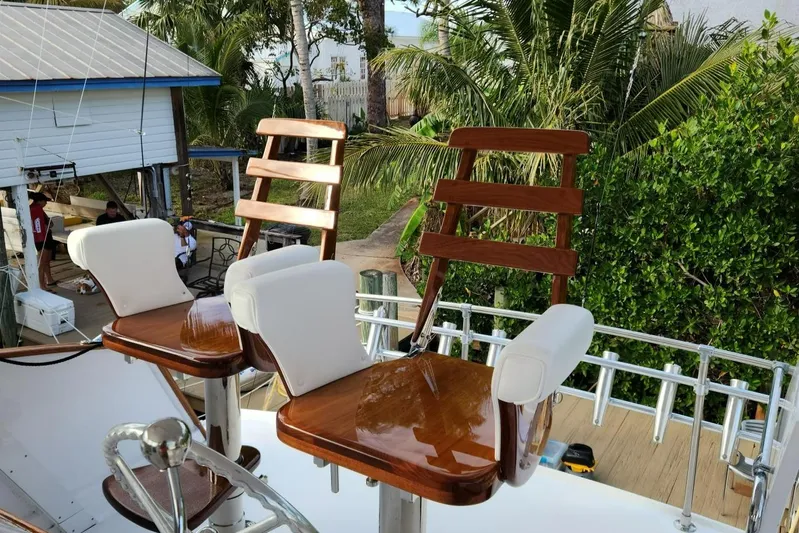 Miss Phebe II Yacht Photos Pics 1971 Whiticar Sportfish boat with polished wooden chairs and lush greenery in the background.