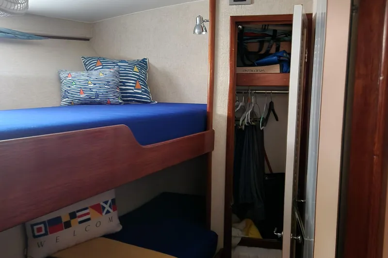 Miss Phebe II Yacht Photos Pics 1971 Whiticar Sportfish cabin with bunk beds and closet, featuring nautical-themed decor.