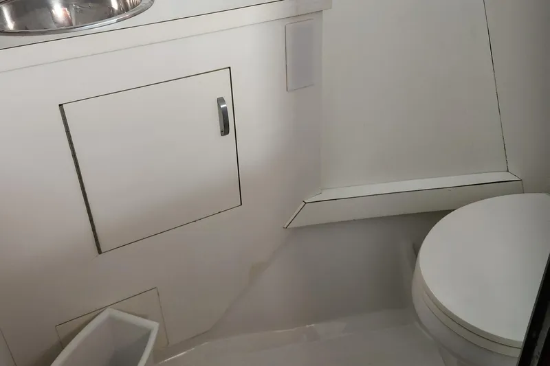 Miss Phebe II Yacht Photos Pics 1971 Whiticar Sportfish boat bathroom with white cabinetry and toilet.