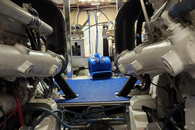 Miss Phebe II Yacht Photos Pics Engine room of a 1971 Whiticar Sportfish boat, featuring dual engines and blue flooring.