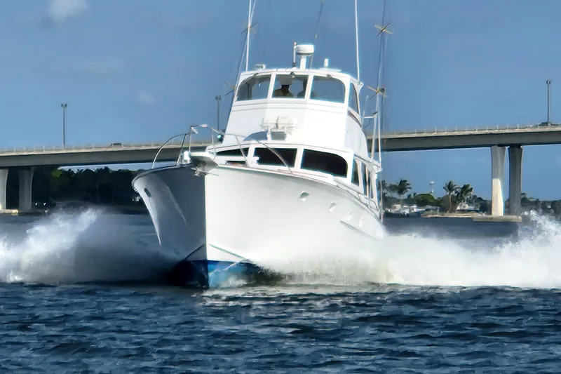  Yacht Photos Pics 1971 Whiticar Sportfish boat cruising on water near a bridge under clear skies.