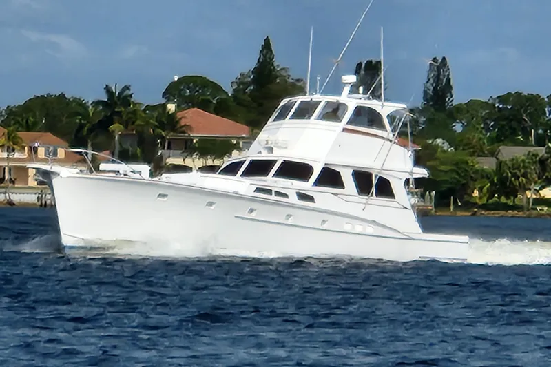  Yacht Photos Pics 1971 Whiticar Sportfish yacht cruising on blue water near coastal homes.