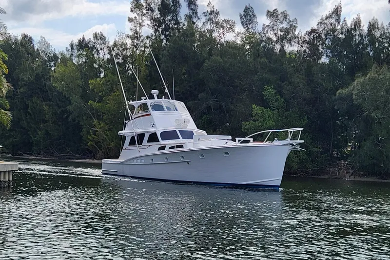 Miss Phebe II Yacht Photos Pics 1971 Whiticar Sportfish boat cruising on a calm river, surrounded by lush trees.