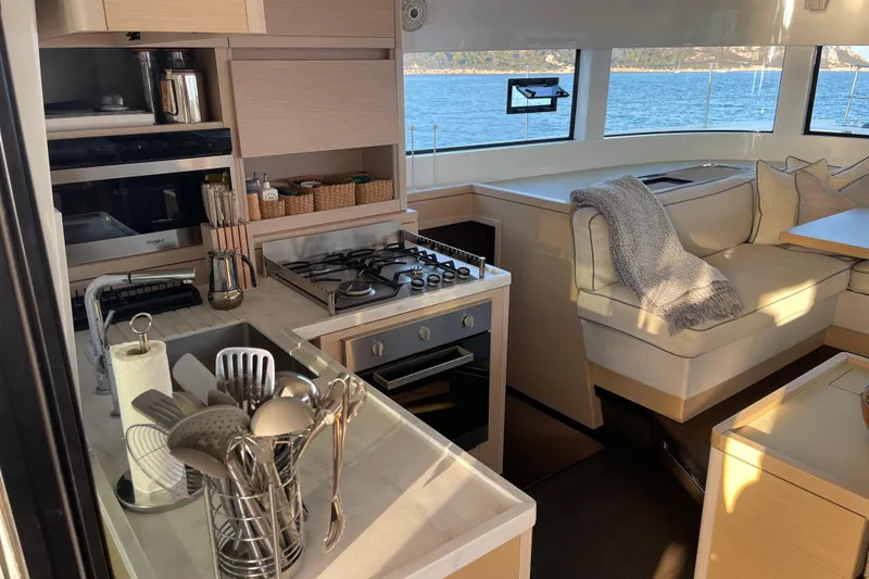  Yacht Photos Pics Modern kitchen and lounge area inside a 2021 Lagoon 50 catamaran with ocean view.