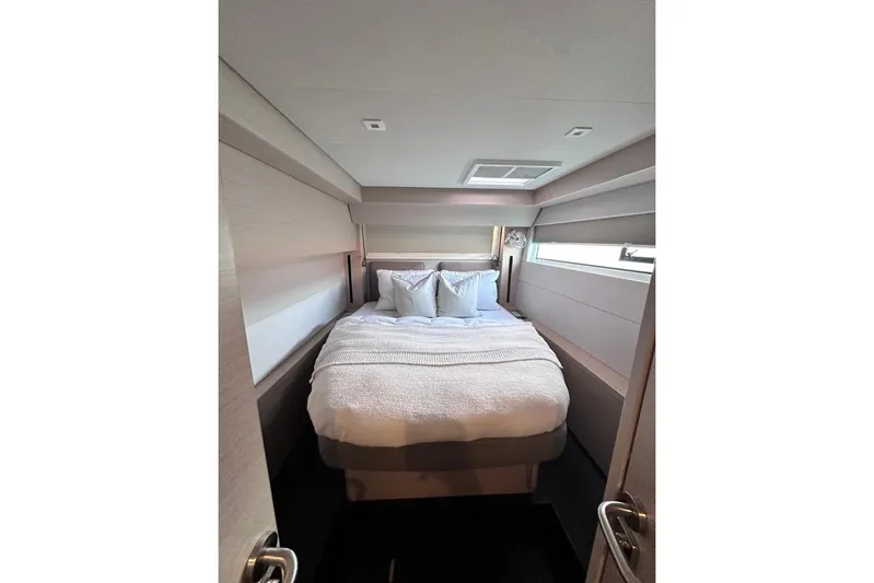  Yacht Photos Pics Luxurious bedroom interior of 2021 Lagoon 50 yacht with cozy bedding.